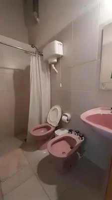 a bathroom with a pink toilet and a sink at Bungalows Aguas Claras in Villa del Dique