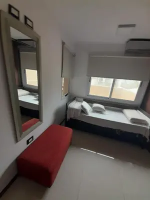 a small room with two beds and a mirror at Miralejos 6 in Villa Carlos Paz