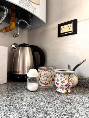 a kitchen counter with a tea pot and a tea kettle at depto a 1 cuadra de peatonal, luminoso con pile y cochera in Villa Carlos Paz