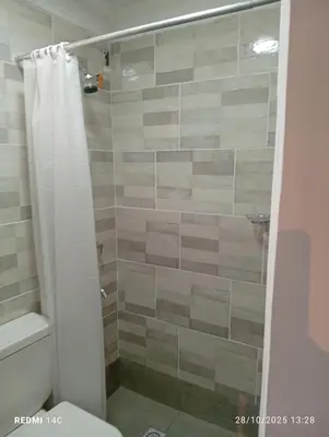 a bathroom with a shower with a white shower curtain at Cabañas ojo de aguila in Panaholma