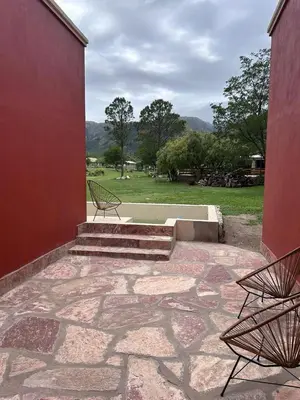 two benches sitting on a patio with a view of a field at Rincón del Benítez in Cortaderas