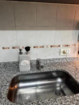 a kitchen sink with a soap dispenser on a counter at Casino Villa Carlos Paz in Villa Carlos Paz