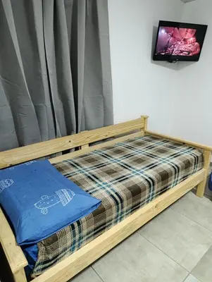 a wooden bed in a room with a tv at Departamento Sinaí Apart in Santa Rosa de Calamuchita