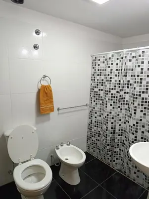 a white bathroom with a toilet and a sink at Departamento Sinaí Apart in Santa Rosa de Calamuchita