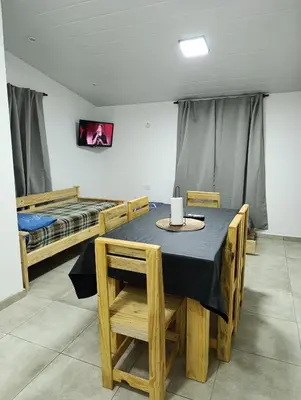 a dining room with a table and two beds at Departamento Sinaí Apart in Santa Rosa de Calamuchita