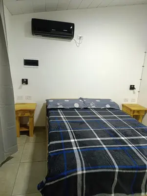 a bedroom with a bed with a blue and white blanket at Departamento Sinaí Apart in Santa Rosa de Calamuchita