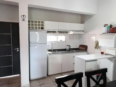 a kitchen with white cabinets and a white refrigerator at Casa Barrancas del Río Anisacate in Villa Anizacate