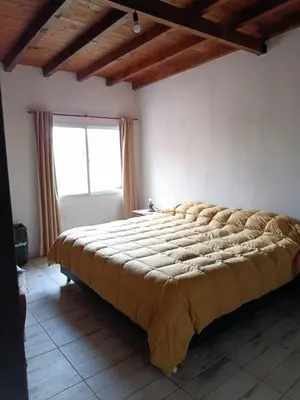 a large bed in a room with a window at Casa Barrancas del Río Anisacate in Villa Anizacate