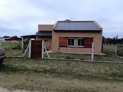 a house with a wooden fence in front of it at Casa Barrancas del Río Anisacate in Villa Anizacate