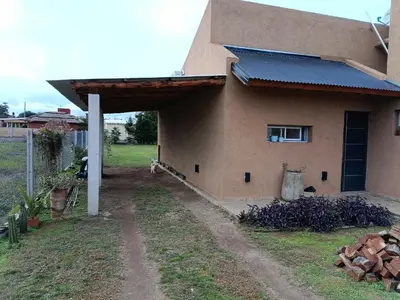 a side view of a house with a garage at Casa Barrancas del Río Anisacate in Villa Anizacate
