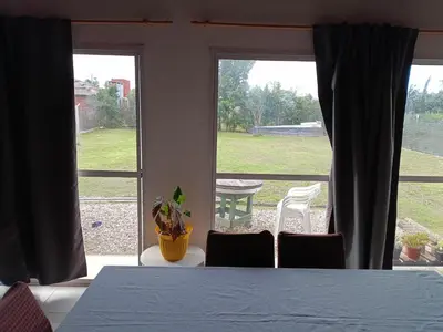 a dining room with a table and a large window at Casa Barrancas del Río Anisacate in Villa Anizacate