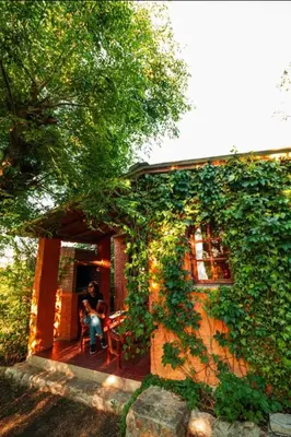 a person sitting on the porch of a house at Las Pircas Apartamentos de Campo in Las Calles