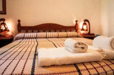 a bedroom with two towels on a bed at Las Pircas Apartamentos de Campo in Las Calles