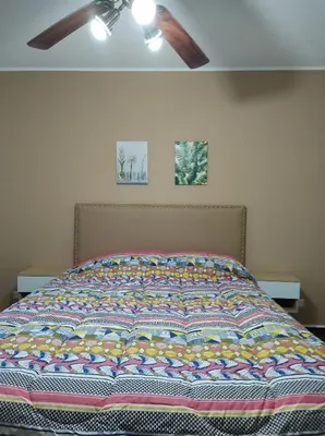 a bed with a colorful quilt on it in a bedroom at Cabañas El Ceibo in La Bolsa