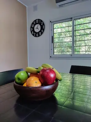a bowl of fruit on a table with a clock at Cabañas El Ceibo in La Bolsa