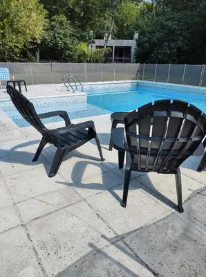 two black chairs sitting next to a swimming pool at Cabañas El Ceibo in La Bolsa