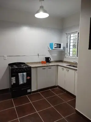 a kitchen with a black stove and a microwave at Cabañas El Ceibo in La Bolsa