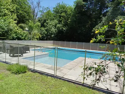 a fence around a swimming pool in a yard at Cabañas El Ceibo in La Bolsa