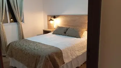 a bedroom with a bed with a wooden headboard at Don Andrés y doña cuca in Merlo