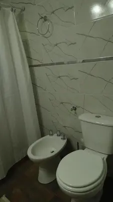 a bathroom with a white toilet and a sink at Don Andrés y doña cuca in Merlo