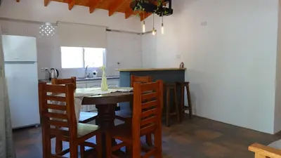 a kitchen with a table and chairs and a refrigerator at Don Andrés y doña cuca in Merlo