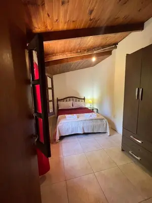 a bedroom with a bed and a wooden ceiling at Pequeño chalet con frente al arroyo in Villa General Belgrano