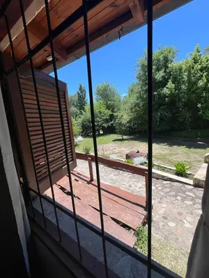 a view from a window looking out at a yard at Pequeño chalet con frente al arroyo in Villa General Belgrano