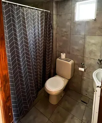 a small bathroom with a toilet and a sink at Pequeño chalet con frente al arroyo in Villa General Belgrano