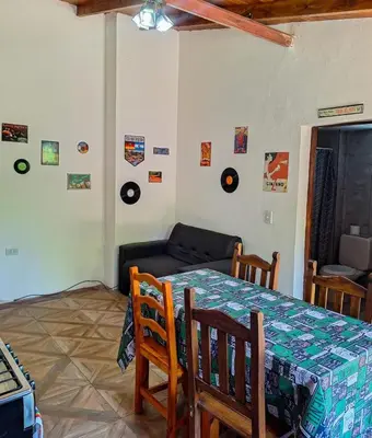 a living room with a table and a couch at Pequeño chalet con frente al arroyo in Villa General Belgrano