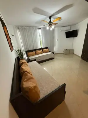 a living room with a couch and a ceiling fan at Dpto amplio con piscina, Excelente ubicación in Villa Carlos Paz