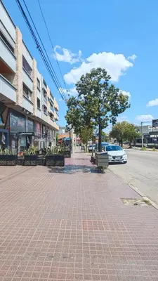 a sidewalk with a tree and a car on a street at Dpto amplio con piscina, Excelente ubicación in Villa Carlos Paz
