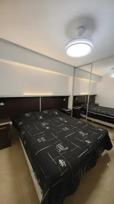 a room with a bed with a black blanket on it at Dpto amplio con piscina, Excelente ubicación in Villa Carlos Paz