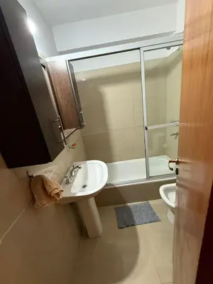 a bathroom with a sink and a shower and a toilet at Dpto amplio con piscina, Excelente ubicación in Villa Carlos Paz