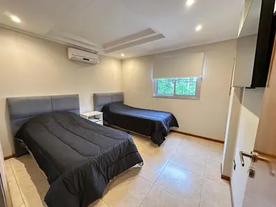 a bedroom with two beds and a window at Departamentos Sol y Lago in Villa Carlos Paz