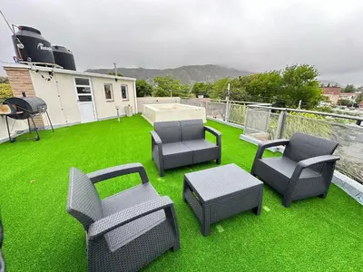 a patio with chairs and a grill on the grass at Departamentos Sol y Lago in Villa Carlos Paz