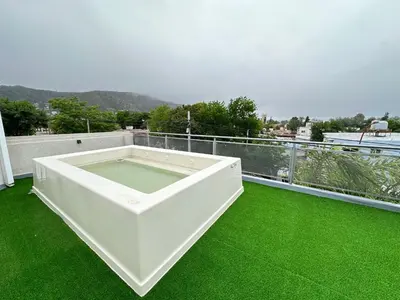 a white tub on a balcony with green grass at Departamentos Sol y Lago in Villa Carlos Paz