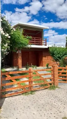 a house with a wooden fence in front of it at La casa del pino in Mina Clavero