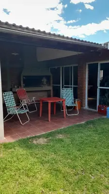 a patio with two chairs and a red table and chairs at La casa del pino in Mina Clavero