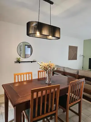 a dining room table with chairs and a vase of flowers at Luminoso departamento in Cordoba