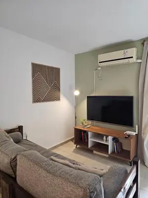 a living room with a couch and a flat screen tv at Luminoso departamento in Cordoba