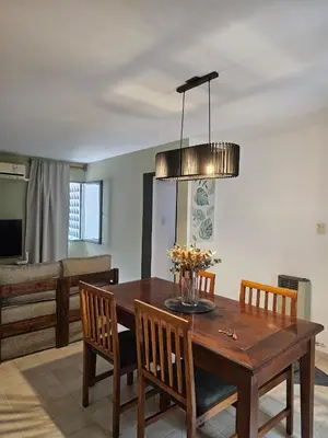 a dining room with a wooden table and chairs at Luminoso departamento in Cordoba