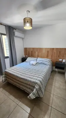 a bedroom with a bed and a chandelier at Luminoso departamento in Cordoba