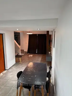 a dining room with a table and a living room at Altos de Las Jarillas in San Antonio de Arredondo