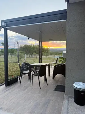 a patio with chairs and a table with a view of a field at Altos de Las Jarillas in San Antonio de Arredondo