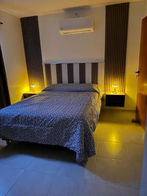 a bedroom with a bed with a blue comforter at Altos de Las Jarillas in San Antonio de Arredondo