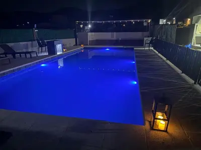 a swimming pool with blue lights in the night at Altos de Las Jarillas in San Antonio de Arredondo