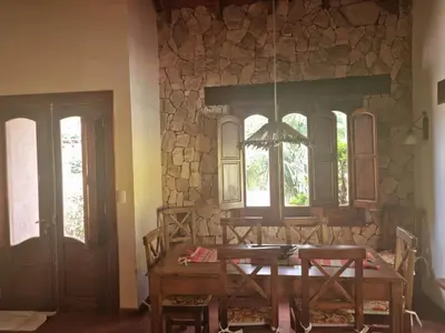a dining room with a table and chairs and a stone wall at Casa en Nono para 6 personas in Nono