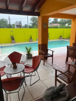 a patio with a table and chairs next to a pool at Casa en Nono para 6 personas in Nono