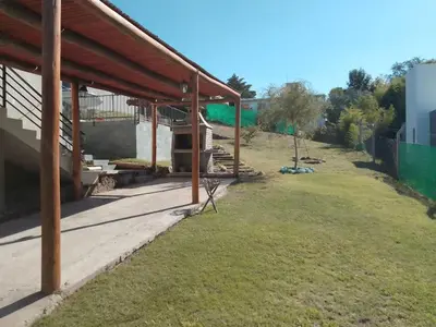 a patio of a house with a grass yard at Alojamiento El Pucará in San Antonio de Arredondo