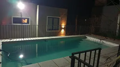 a swimming pool at night with a motorcycle in it at Alojamiento El Pucará in San Antonio de Arredondo